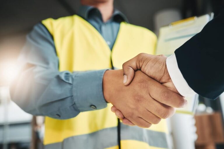 Construction worker shaking hand with Lubricant sales rep 