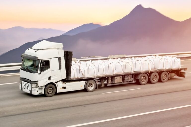 Flatbed truck carrying construction / building material.