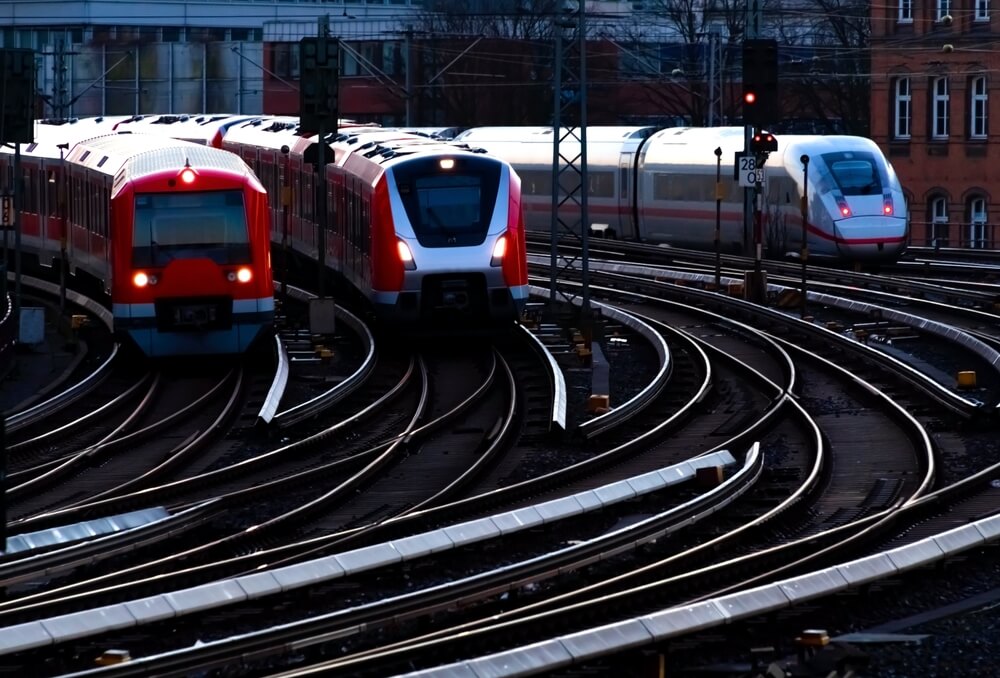 Three passenger trains leaving a station.
