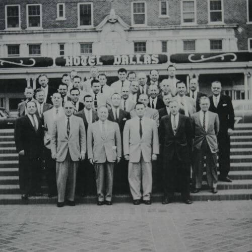 Group of sales and associates from National Disinfectants (NCH) standing on steps in front of a hotel in Dallas.