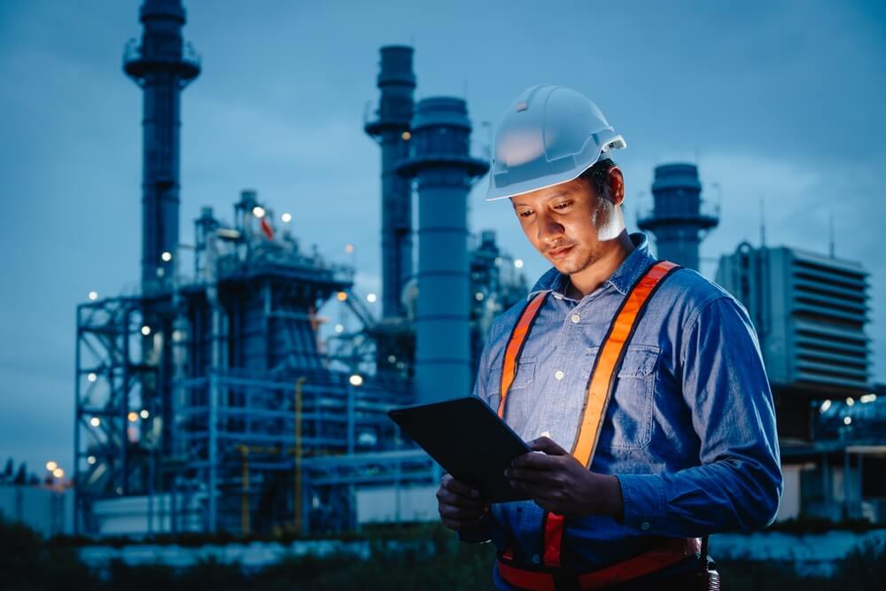 engineer oil and gas refinery service, male worker hard work in petroleum industry plant dark background.